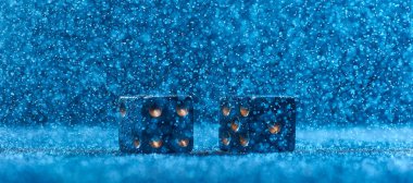 Two black dices on a blue bokeh background. The concept of gambling. clipart