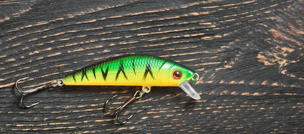 Fishing lure green Wobbler closeup on gray wooden background. — Stock Photo, Image