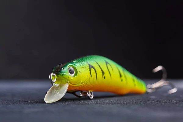 Fishing lure green used Wobbler closeup on black background. Hooks and background in blur. — Stock Photo, Image