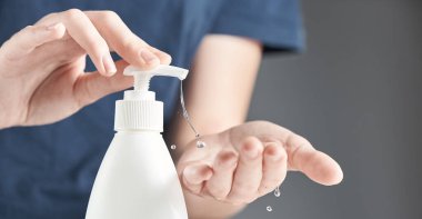 Female hands using hand sanitizer gel pump dispenser. The concept of hand disinfection. clipart