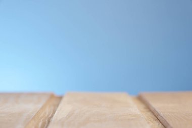 Mavi ışıklı arka planda bulanık bir şekilde ahşap yüzeyin yatay görüntüsü. Fotoğraf: Kopyalama uzayından.