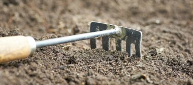 Zeminin arka planında bulanık olarak tırmığın yatay görüntüsü.