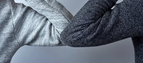 Dirsek çarpması pankartı. Koronavirüsün yayılmasını önlemek için yeni bir selamlama. Sarılmak ya da tokalaşmak yerine, dirseklerini vuruyorlar..
