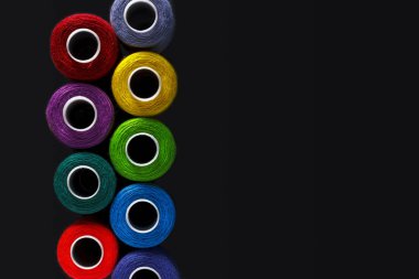 İş parçacığı renkli makaralar siyah arka plan üzerinde ayarlayın. Mockup. Üstten Görünüm. Düz yatıyordu