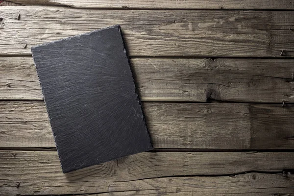 Zwarte leeg leeg schoolbord op achtergrond uit houten planken. Bovenaanzicht. Flatlay — Stockfoto