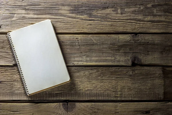 Un simple cahier blanc vide avec un blanc pour dessiner ou écrire se trouve sur un bureau à partir de planches en bois. Vue de dessus. Maquette. Pose plate — Photo