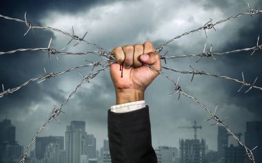 Hand of businessman holding on a barbed wire , Business heavy ta clipart