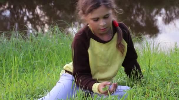 Menina jogando na margem do rio — Vídeo de Stock
