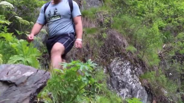 Homem caminha até as rochas da montanha — Vídeo de Stock