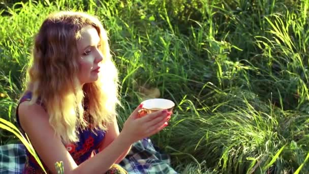 Молода жінка п'є гарячий чай — стокове відео