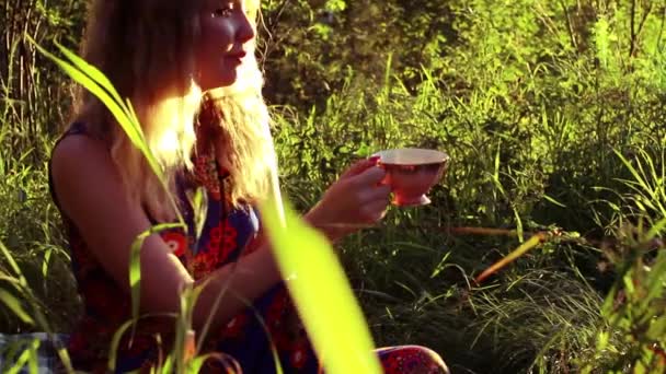 Mujer joven bebiendo té caliente — Vídeo de stock