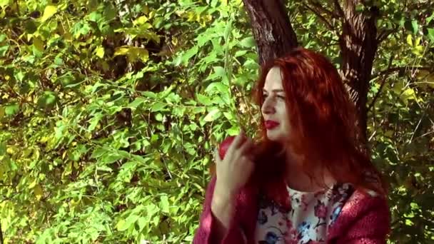 Joven mujer pelirroja en el parque de otoño — Vídeo de stock