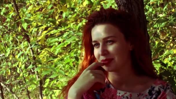 Jonge roodharige vrouw in de herfst park — Stockvideo