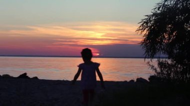 gün batımında sahilde genç bir kız silüeti