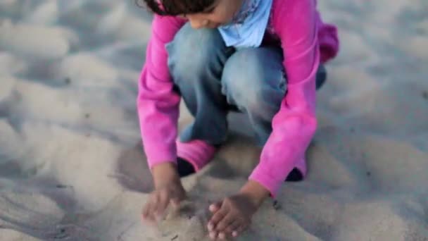 Niña feliz en la playa jugando en la arena — Vídeo de stock