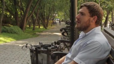adam sigara parkta bankta