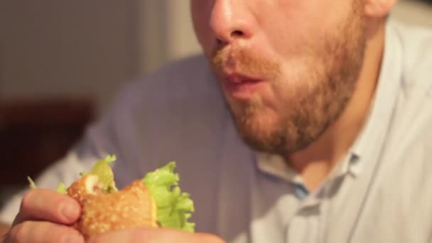 Человек есть аппетитный бургер — стоковое видео