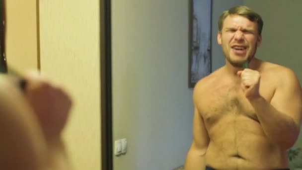 Man sings and dances around the mirror — Stockvideo