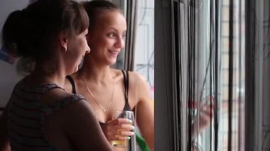 Konuşurken, bira içip pencereden dışarı bakarak neşeli kızlar