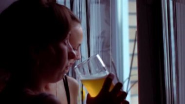 Konuşurken, bira içip pencereden dışarı bakarak neşeli kızlar