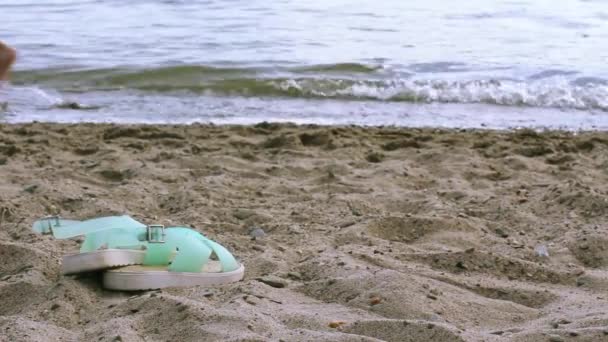 Chaussures de plage allongées sur le sable au bord de la mer — Video