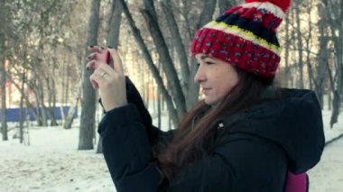 smartphone'unuza kış parkta genç kadın video alır