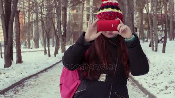 Молода жінка бере відео на свій смартфон в зимовому парку — стокове відео