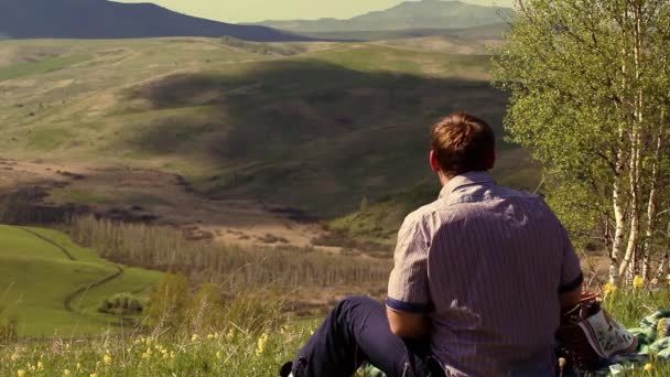 Kaukázusi ember ül a hegyekben, és élvezze a szépség, a természet — Stock videók