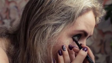 Güzel sarışın kız ayna yakınındaki akşam makyaj yapma