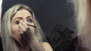 Güzel sarışın kız ayna yakınındaki akşam makyaj yapma