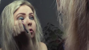 Güzel sarışın kız ayna yakınındaki akşam makyaj yapma