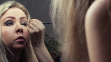 Güzel sarışın kız ayna yakınındaki akşam makyaj yapma