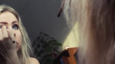 Güzel sarışın kız ayna yakınındaki akşam makyaj yapma