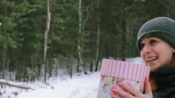 Flicka ger en gåva i vinter utomhus — Stockvideo
