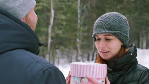 Дівчина дарує подарунок взимку на відкритому повітрі — стокове відео