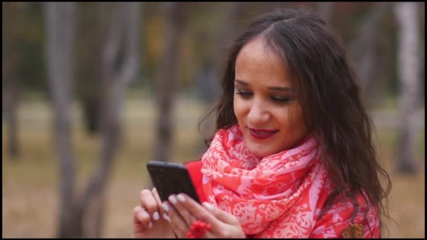 젊은 여자는 전화, 문자 메시지에 인터넷을 검색 하 고 야외에서 채팅. — 비디오