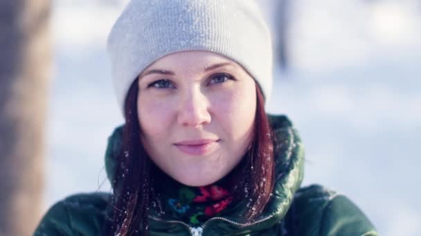 Jeune femme joyeuse jetant de la neige duveteuse dans le parc — Video