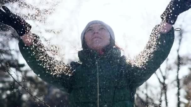 Jovem mulher alegre jogando neve fofa no parque — Vídeo de Stock