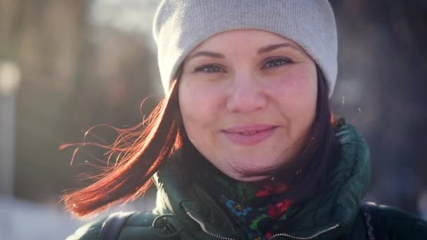 Зимовий портрет чарівної молодої жінки, яка дивиться на камеру — стокове відео