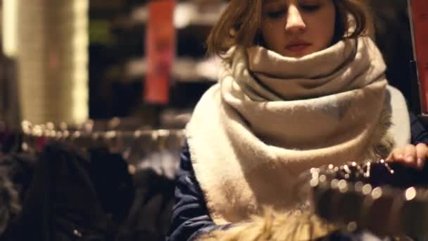 Twee jonge vrouwen shoppen bij het kiezen van de warme winter kleding winkel — Stockvideo