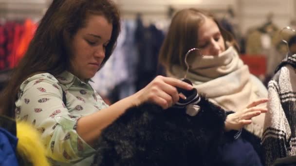 Dwie młode kobiety sklep w sklepie wybór ciepłe zimowe ubrania — Wideo stockowe