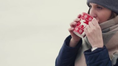 Onu sabah kahve veya çay karlı bir ufuk arka plan üzerinde yürürken genç kadının