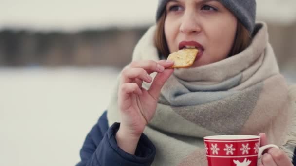 歩きながら彼女のモーニング コーヒーや雪の地平線の背景にお茶を楽しんでいる若い女性 — ストック動画