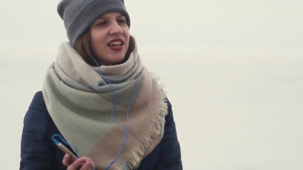 Mooie jonge vrouw dansen luisteren naar muziek tijdens het lopen buiten — Stockvideo