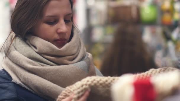 Egy fiatal nő a boltban válassza ki a ruhát meleg télen — Stock videók