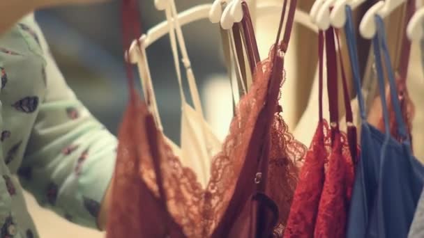 Loja de roupa interior de mulher. Uma mulher escolhe roupa interior de seda — Vídeo de Stock