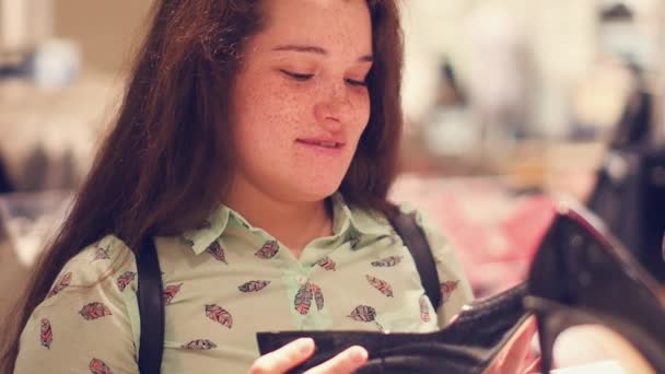 Een jonge vrouw in de winkel kiezen demi-seizoen schoenen — Stockvideo