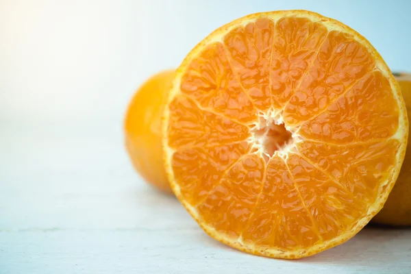 Апельсин, крупним планом цілі апельсинові фрукти і нарізаний апельсин на дереві — стокове фото