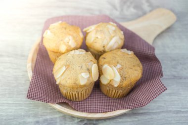 Ev yapımı muz fincan kek ahşap zemin üzerine dilimlenmiş badem ile