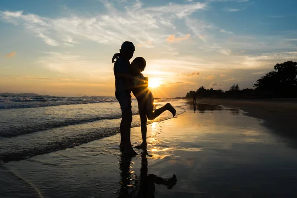 Silhouette von Brüdern, die sich am Strand umarmen — Stockfoto